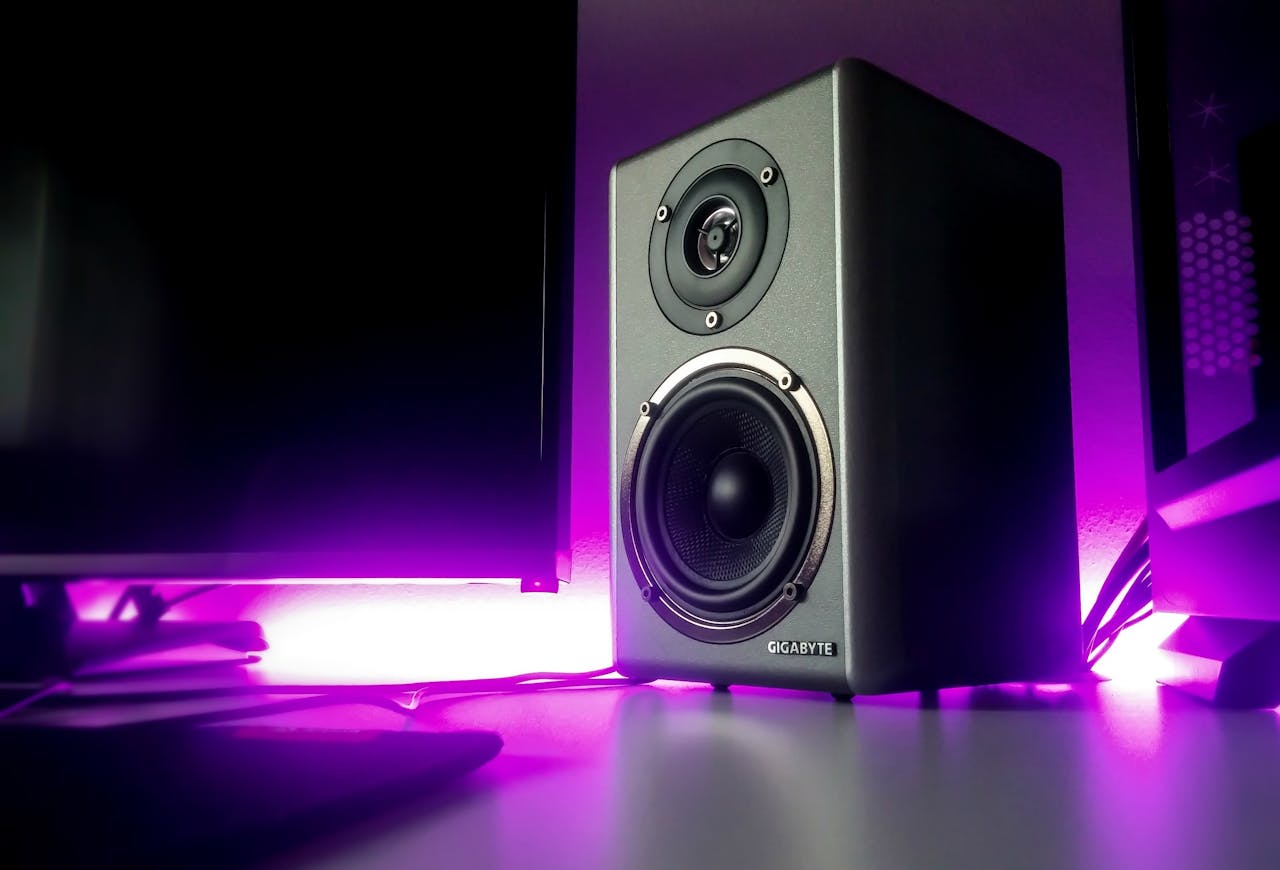 about-us High-quality speaker setup with vibrant purple lighting in a modern studio setting.